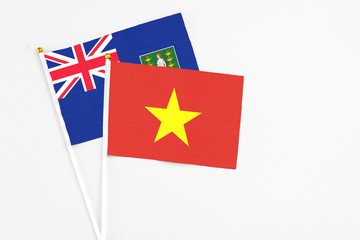 Fototapeta premium Vietnam and British Virgin Islands stick flags on white background. High quality fabric, miniature national flag. Peaceful global concept.White floor for copy space.