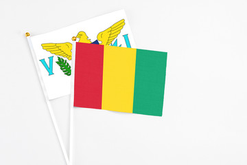 Guinea and United States Virgin Islands stick flags on white background. High quality fabric, miniature national flag. Peaceful global concept.White floor for copy space.