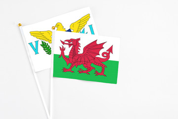 Wales and United States Virgin Islands stick flags on white background. High quality fabric, miniature national flag. Peaceful global concept.White floor for copy space.