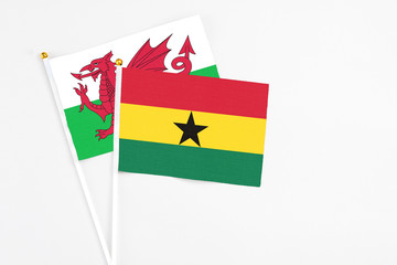 Ghana and Wales stick flags on white background. High quality fabric, miniature national flag. Peaceful global concept.White floor for copy space.