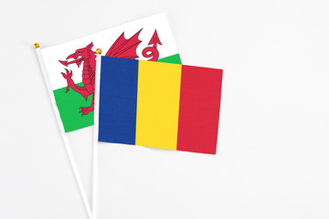 Romania and Wales stick flags on white background. High quality fabric, miniature national flag. Peaceful global concept.White floor for copy space.