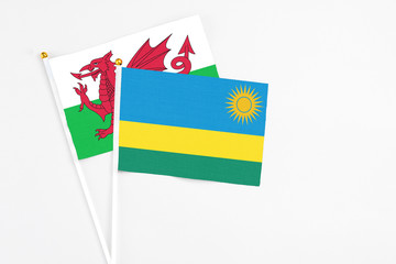 Rwanda and Wales stick flags on white background. High quality fabric, miniature national flag. Peaceful global concept.White floor for copy space.