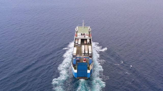 Aerial follow footage of a Large RoRo (Roll on/off) Vehicle carrier vessel cruising the Mediterranean sea.