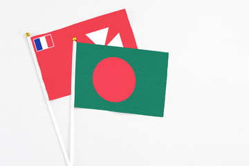 Bangladesh and Wallis And Futuna stick flags on white background. High quality fabric, miniature national flag. Peaceful global concept.White floor for copy space.