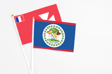 Belize and Wallis And Futuna stick flags on white background. High quality fabric, miniature national flag. Peaceful global concept.White floor for copy space.