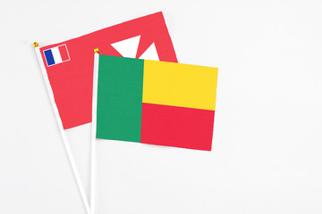 Benin and Wallis And Futuna stick flags on white background. High quality fabric, miniature national flag. Peaceful global concept.White floor for copy space.
