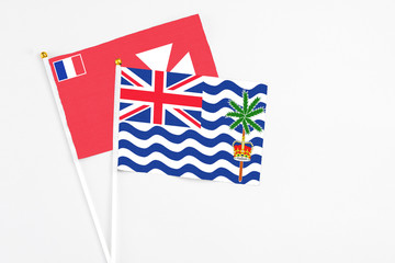Fototapeta premium British Indian Ocean Territory and Wallis And Futuna stick flags on white background. High quality fabric, miniature national flag. Peaceful global concept.White floor for copy space.