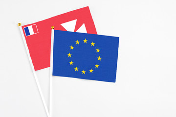 European Union and Wallis And Futuna stick flags on white background. High quality fabric, miniature national flag. Peaceful global concept.White floor for copy space.
