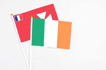 Ireland and Wallis And Futuna stick flags on white background. High quality fabric, miniature national flag. Peaceful global concept.White floor for copy space.