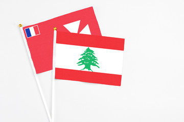 Lebanon and Wallis And Futuna stick flags on white background. High quality fabric, miniature national flag. Peaceful global concept.White floor for copy space.