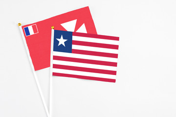 Liberia and Wallis And Futuna stick flags on white background. High quality fabric, miniature national flag. Peaceful global concept.White floor for copy space.