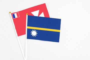 Nauru and Wallis And Futuna stick flags on white background. High quality fabric, miniature national flag. Peaceful global concept.White floor for copy space.