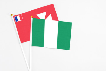 Nigeria and Wallis And Futuna stick flags on white background. High quality fabric, miniature national flag. Peaceful global concept.White floor for copy space.