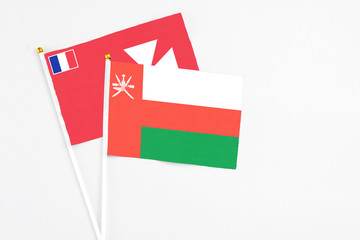 Oman and Wallis And Futuna stick flags on white background. High quality fabric, miniature national flag. Peaceful global concept.White floor for copy space.