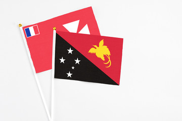 Papua New Guinea and Wallis And Futuna stick flags on white background. High quality fabric, miniature national flag. Peaceful global concept.White floor for copy space.