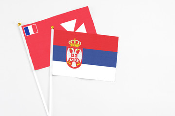 Serbia and Wallis And Futuna stick flags on white background. High quality fabric, miniature national flag. Peaceful global concept.White floor for copy space.