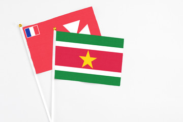 Suriname and Wallis And Futuna stick flags on white background. High quality fabric, miniature national flag. Peaceful global concept.White floor for copy space.
