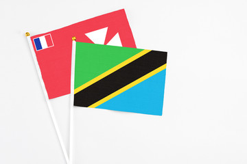Tanzania and Wallis And Futuna stick flags on white background. High quality fabric, miniature national flag. Peaceful global concept.White floor for copy space.