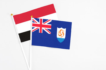 Fototapeta premium Anguilla and Yemen stick flags on white background. High quality fabric, miniature national flag. Peaceful global concept.White floor for copy space.