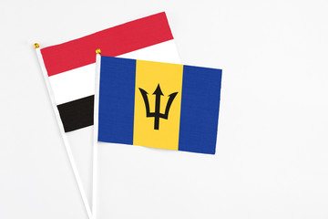 Barbados and Yemen stick flags on white background. High quality fabric, miniature national flag. Peaceful global concept.White floor for copy space.