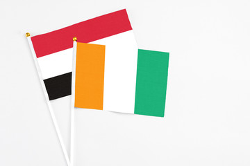 Cote D'Ivoire and Yemen stick flags on white background. High quality fabric, miniature national...