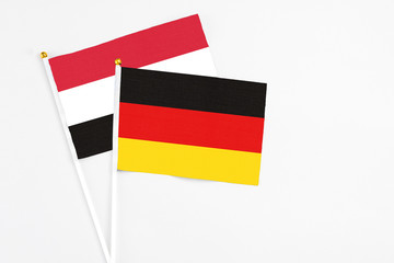 Germany and Yemen stick flags on white background. High quality fabric, miniature national flag. Peaceful global concept.White floor for copy space.