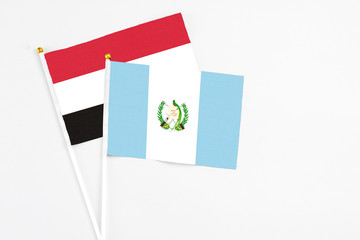 Guatemala and Yemen stick flags on white background. High quality fabric, miniature national flag. Peaceful global concept.White floor for copy space.