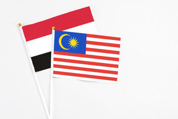 Malaysia and Yemen stick flags on white background. High quality fabric, miniature national flag. Peaceful global concept.White floor for copy space.