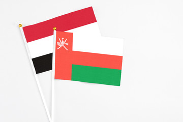 Oman and Yemen stick flags on white background. High quality fabric, miniature national flag. Peaceful global concept.White floor for copy space.