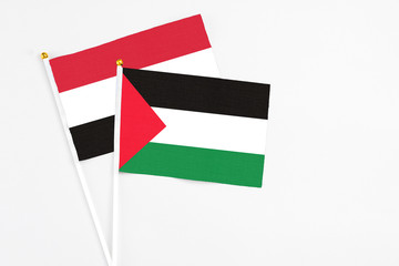 Palestine and Yemen stick flags on white background. High quality fabric, miniature national flag. Peaceful global concept.White floor for copy space.