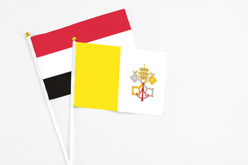 Vatican City and Yemen stick flags on white background. High quality fabric, miniature national flag. Peaceful global concept.White floor for copy space.