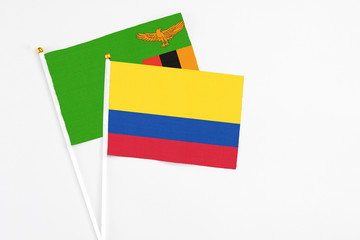 Colombia and Zambia stick flags on white background. High quality fabric, miniature national flag. Peaceful global concept.White floor for copy space.