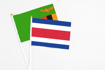 Costa Rica and Zambia stick flags on white background. High quality fabric, miniature national flag. Peaceful global concept.White floor for copy space.