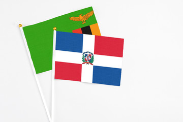 Dominican Republic and Zambia stick flags on white background. High quality fabric, miniature national flag. Peaceful global concept.White floor for copy space.