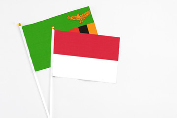 Indonesia and Zambia stick flags on white background. High quality fabric, miniature national flag. Peaceful global concept.White floor for copy space.