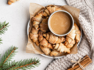 Fototapeta na wymiar Homemade christmas croissants (crescent rolls) on a wooden tray with fir tree branches and cinnamon sticks . Christmas and new year background, layout template.