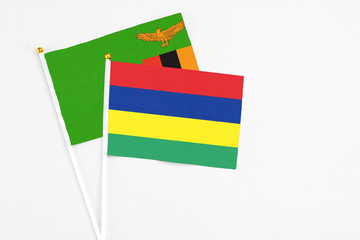 Mauritius and Zambia stick flags on white background. High quality fabric, miniature national flag. Peaceful global concept.White floor for copy space.