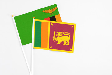 Sri Lanka and Zambia stick flags on white background. High quality fabric, miniature national flag. Peaceful global concept.White floor for copy space.