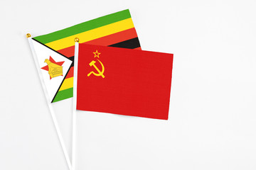 Soviet Union and Zimbabwe stick flags on white background. High quality fabric, miniature national flag. Peaceful global concept.White floor for copy space.