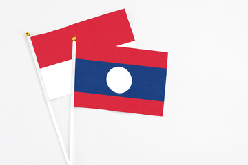 Laos and Indonesia stick flags on white background. High quality fabric, miniature national flag. Peaceful global concept.White floor for copy space.