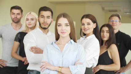 A group of young cheerful people are looking forward and up They are located in an office spacious light room