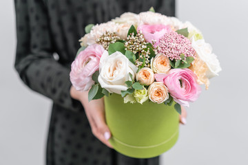 European floral shop. Floral bunch in round box. Bouquet of beautiful Mixed flowers in woman hand. Excellent garden flowers in the arrangement , the work of a professional florist.