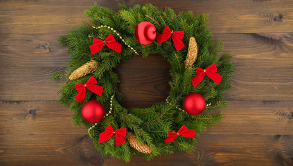 Christmas wreath of fir branches with cones on a dark wooden background