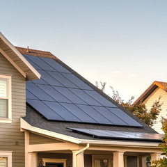 Square Solar photovoltaic panels on a house roof © Jason