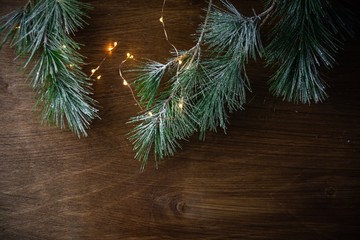 Weihnachten Hintergrund - Kiefernzweig mit lichterkette vor rustikalem Holzhintergrund
