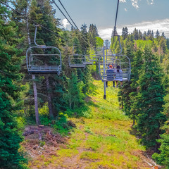 Square frame Chairlift with tourists over hiking trail in Park City mountain at off season