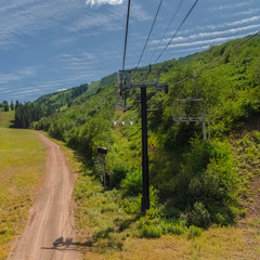 Square frame Hiking trails and chairlifts on a scenic mountain with lush trees at off season