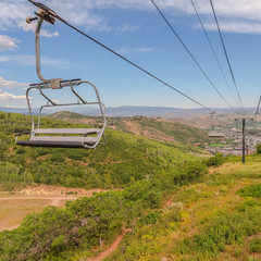 Square frame Off season months in Park City ski resort with focus on chairlifts against sky