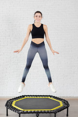 girl engaged in fitness on the mini trampoline . perform exercises on the trampoline.A slim...