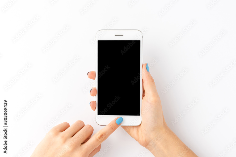 Wall mural female hands holding smart phone with empty screen isolated on white background. top view